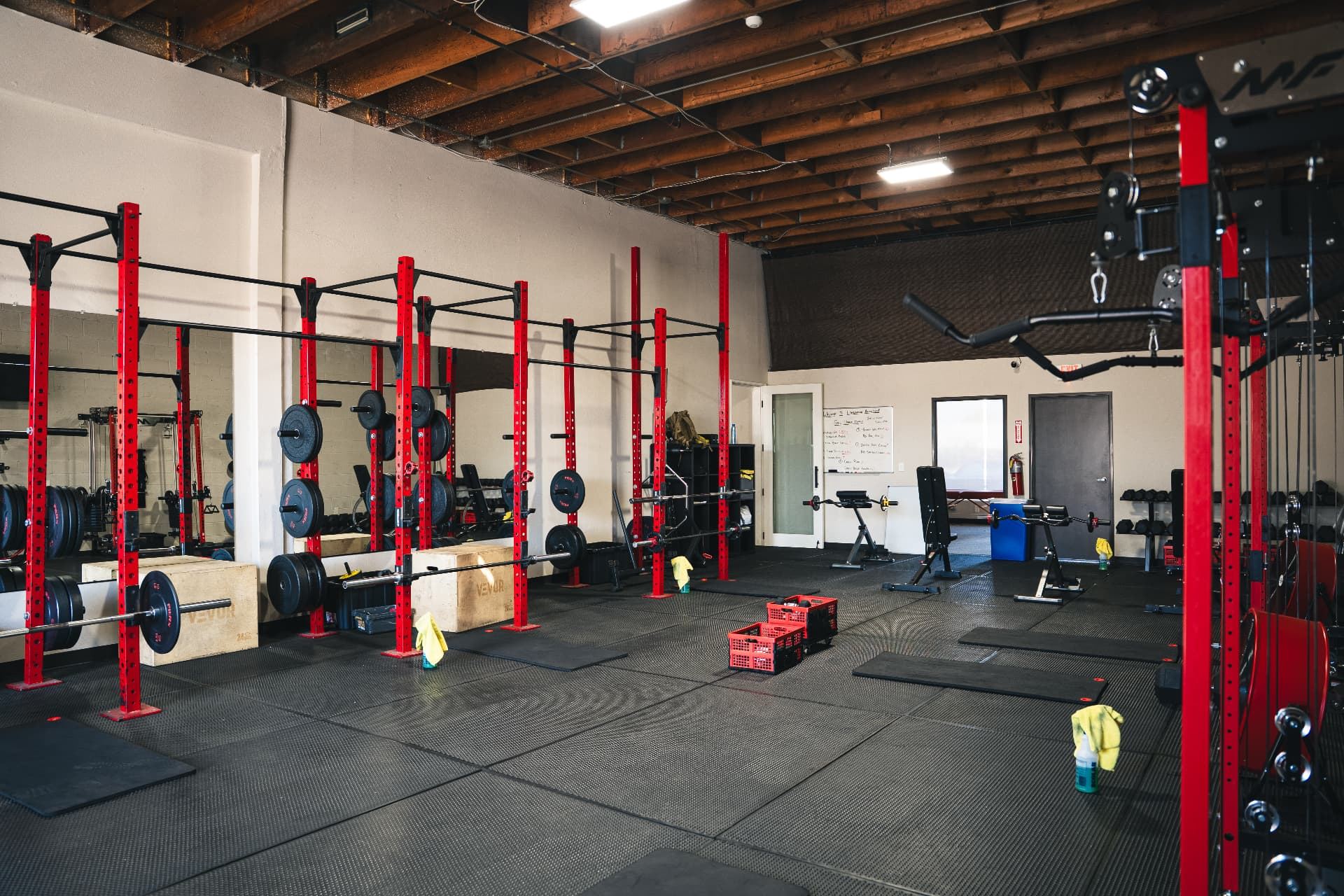Row of red and black squat racks at LionStrong Athletics